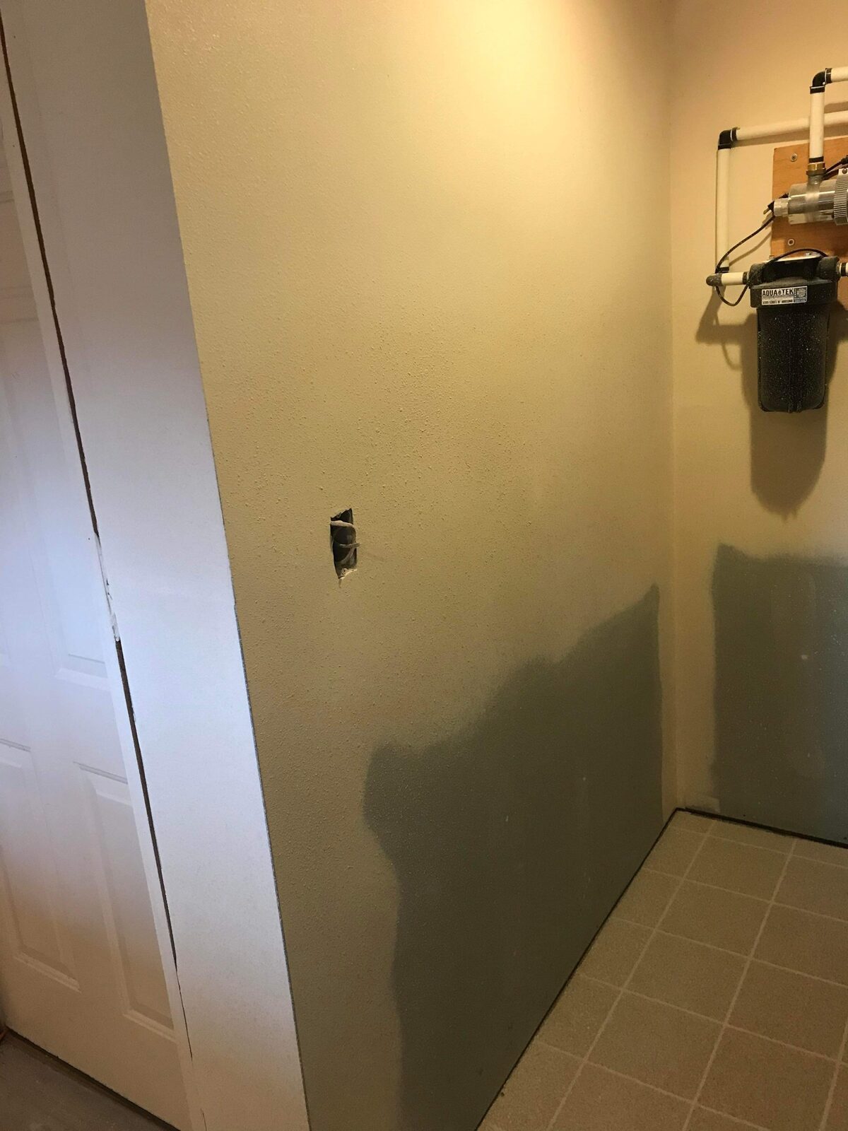 New drywall installed during a utility room wall repair